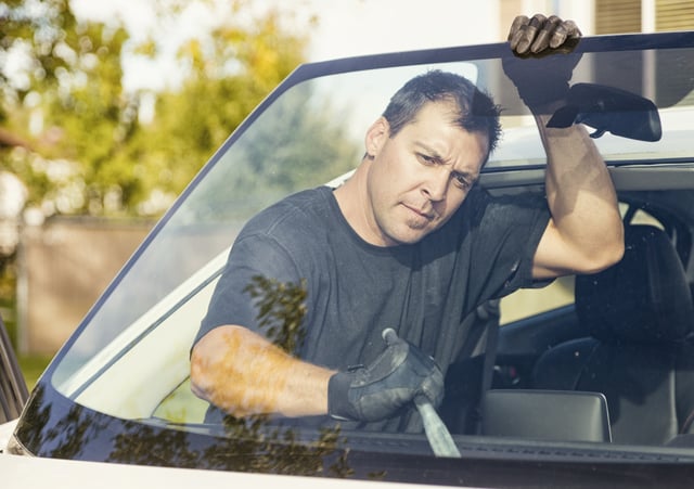 A technician replacing the windshield on a passenger car.